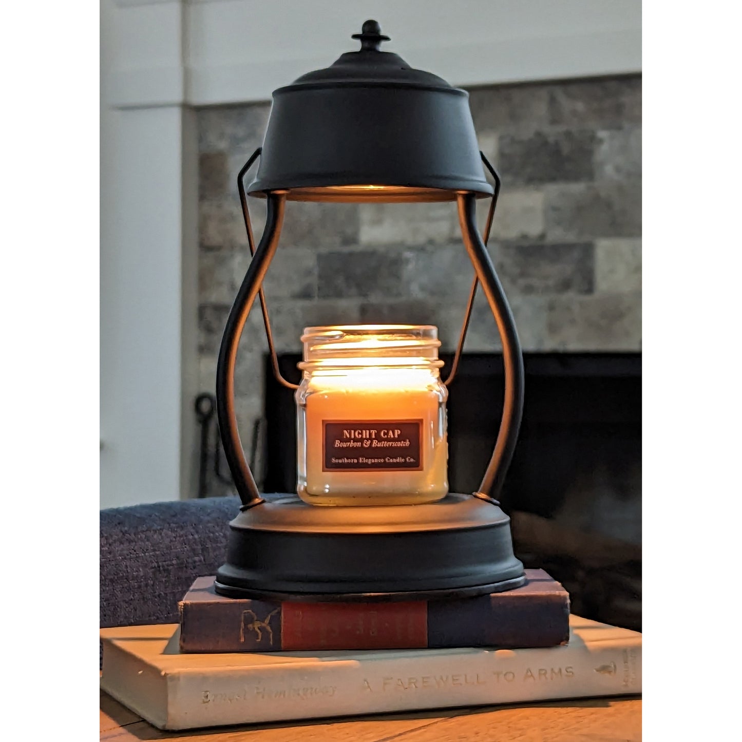 Image, lighted black candle warmer on coffee table with small scented candle.