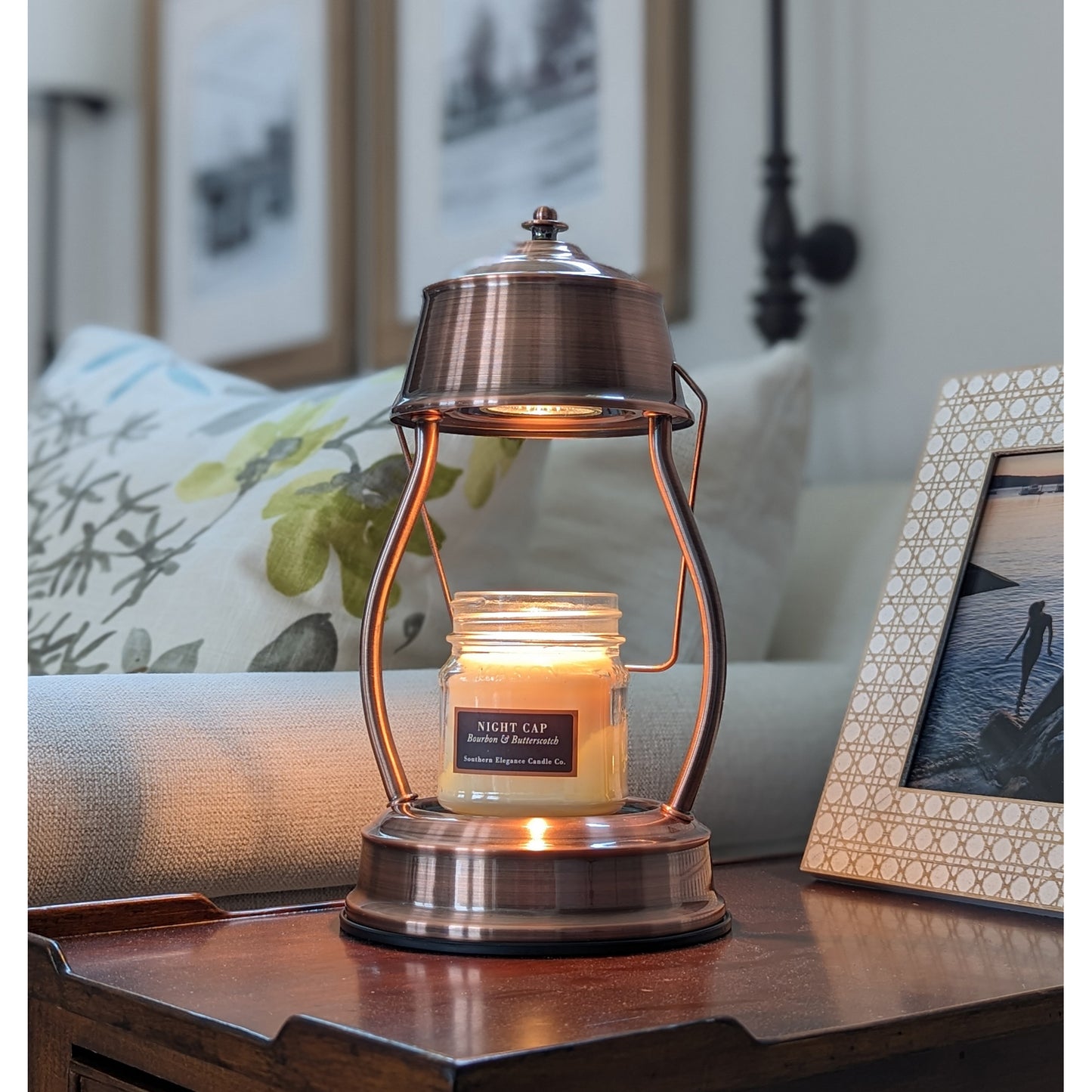 Image, lighted copper candle warmer on coffee table with small scented candle.